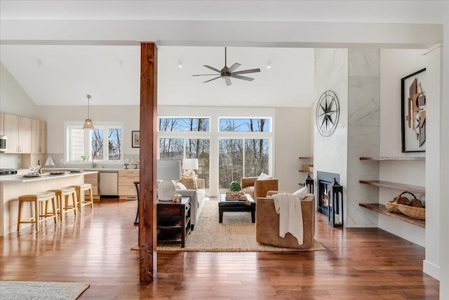 sitting room with a fireplace, high vaulted ceiling, dark hardwood / wood-style floors, and ceiling fan