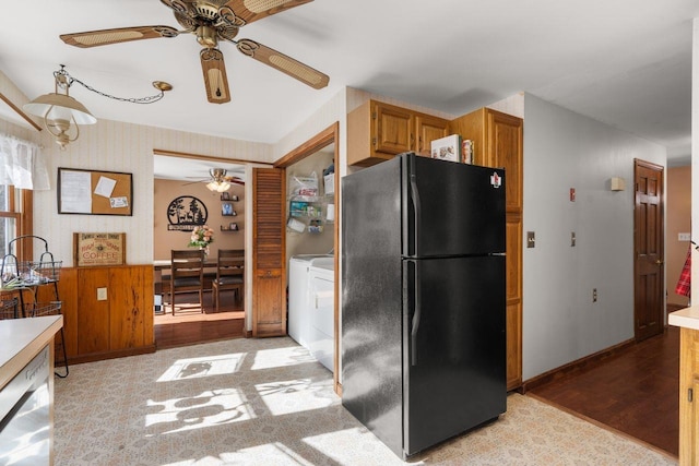 kitchen featuring dishwasher, light hardwood / wood-style flooring, separate washer and dryer, and black fridge