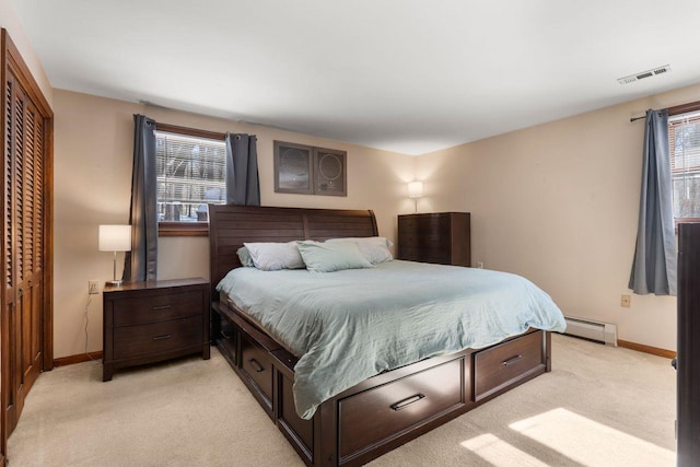 carpeted bedroom featuring a closet and baseboard heating