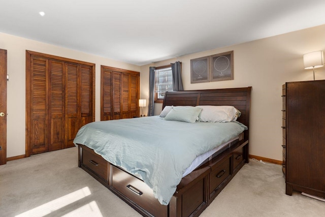 bedroom with two closets and light colored carpet