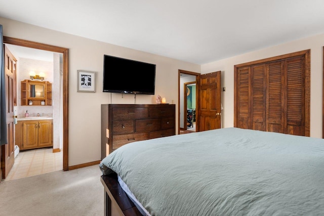 bedroom featuring light carpet, a closet, sink, and connected bathroom