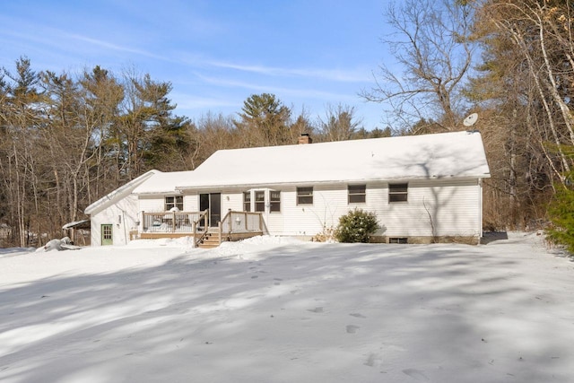 snow covered rear of property featuring a deck