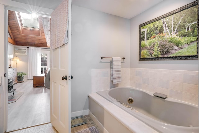 bathroom with a wall mounted air conditioner, hardwood / wood-style flooring, a skylight, and a bathing tub