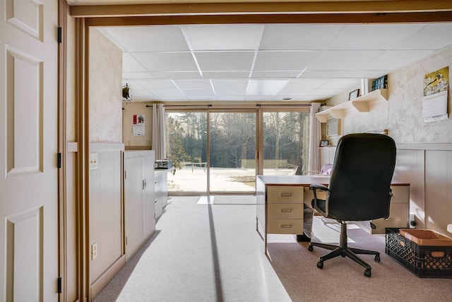 office space featuring a paneled ceiling and light carpet