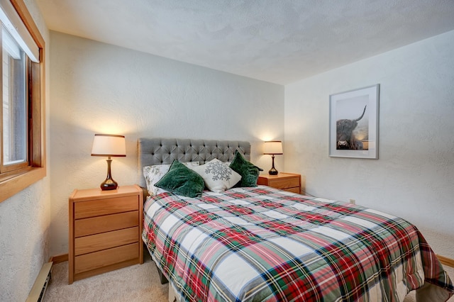 bedroom featuring light carpet, a textured wall, and a baseboard heating unit