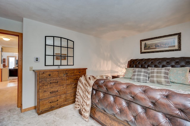 bedroom featuring light carpet and baseboards