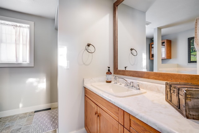 bathroom with baseboards, visible vents, and vanity