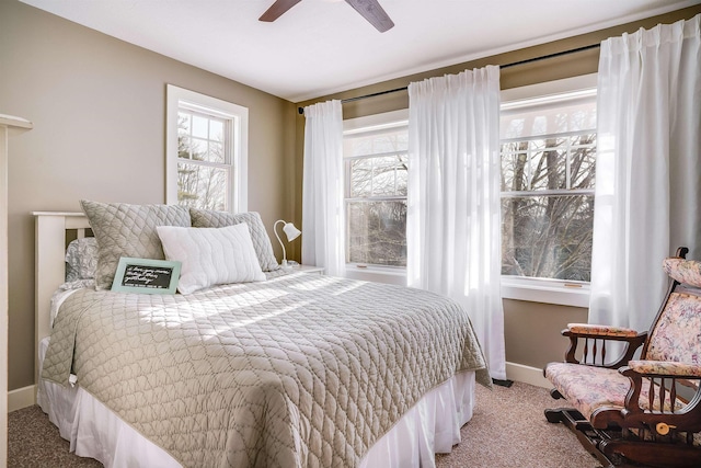 carpeted bedroom featuring baseboards and a ceiling fan