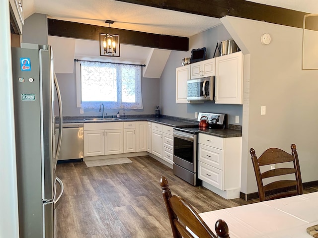 kitchen featuring appliances with stainless steel finishes, decorative light fixtures, sink, and white cabinets