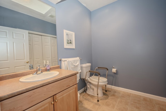 bathroom with vanity, baseboards, visible vents, toilet, and a closet