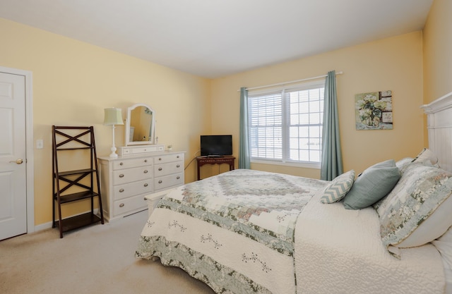 bedroom with baseboards and light carpet