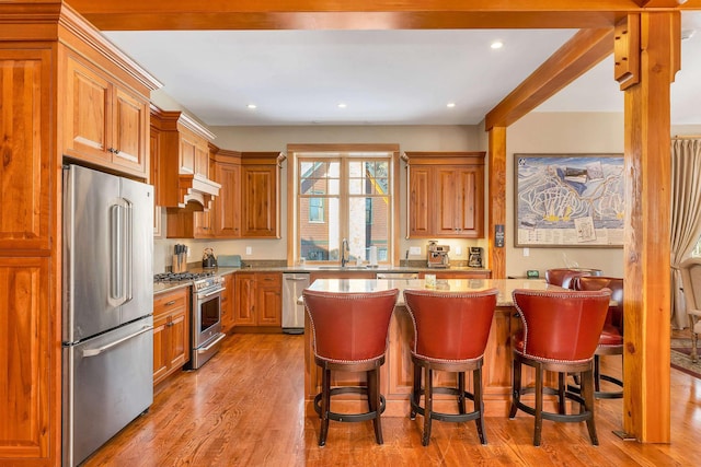 kitchen featuring a breakfast bar, a kitchen island, a sink, and premium appliances