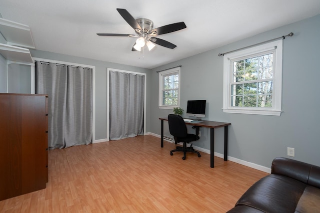 office space with baseboards, a ceiling fan, and light wood-type flooring