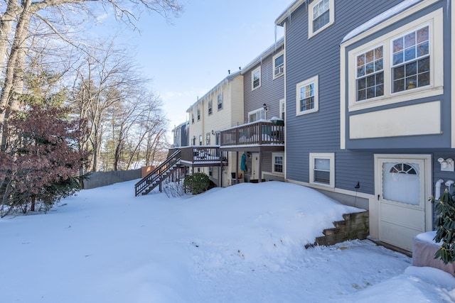 yard covered in snow with a wooden deck and stairs