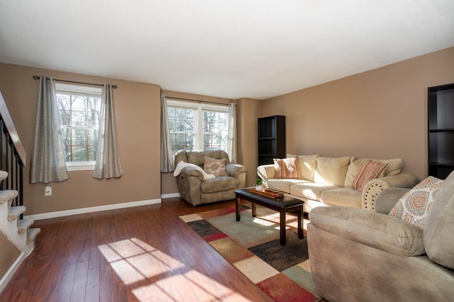 living area with baseboards, a wealth of natural light, stairs, and dark wood finished floors