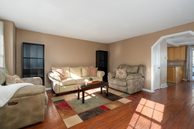 living area with baseboards and dark wood-type flooring