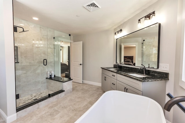 full bath with ensuite bathroom, visible vents, a sink, and a freestanding tub