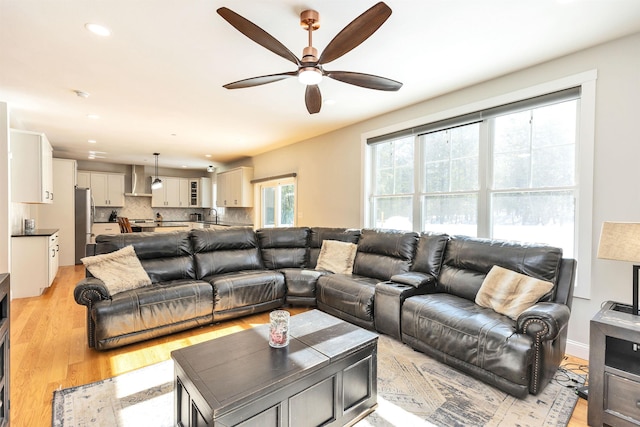 living room featuring light wood-type flooring, recessed lighting, baseboards, and ceiling fan