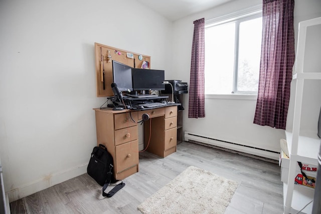 office area featuring baseboard heating, light wood-type flooring, and baseboards