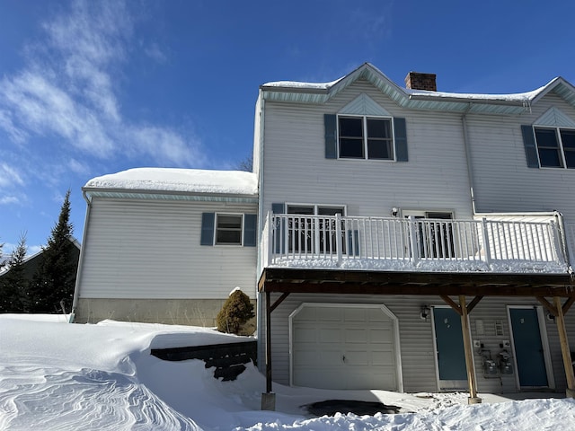 snow covered house featuring a chimney