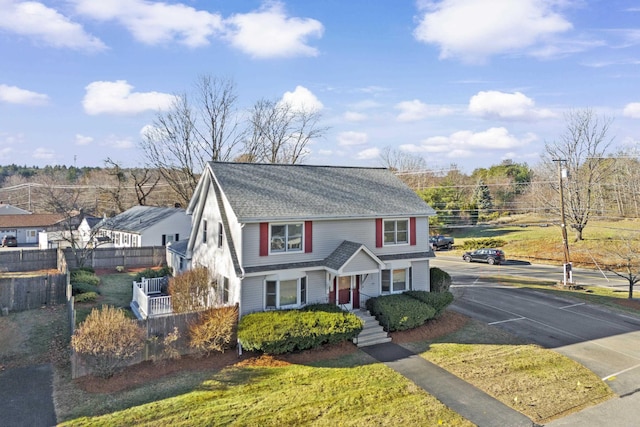 view of front of house with a shingled roof and fence