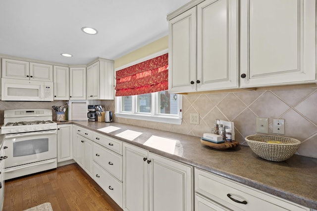 kitchen featuring dark wood-type flooring, white appliances, white cabinetry, and backsplash