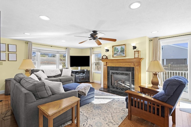 living room with a fireplace, baseboards, and wood finished floors