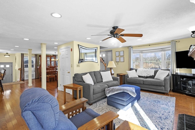 living room featuring stairs, recessed lighting, light wood-type flooring, and ornate columns