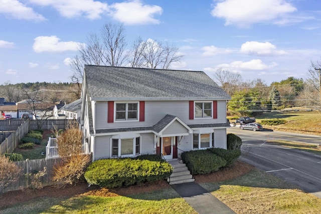 view of front of property featuring fence and roof with shingles