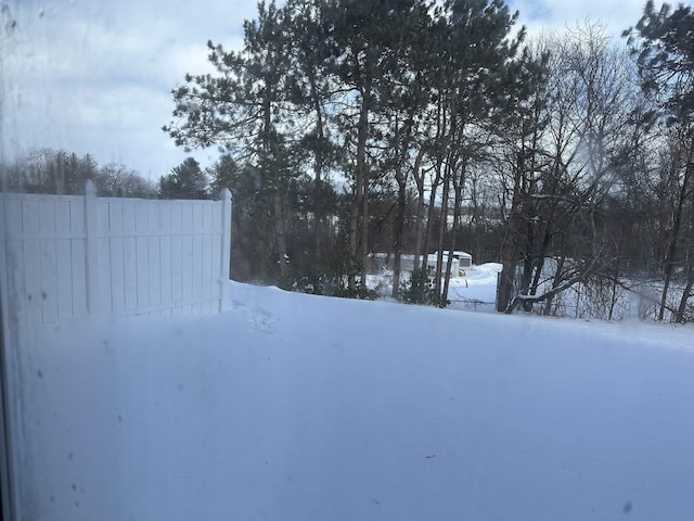 yard layered in snow with fence