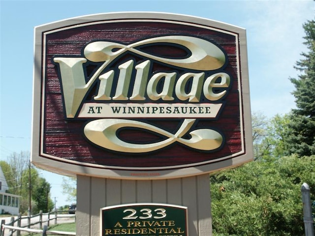 community / neighborhood sign featuring fence