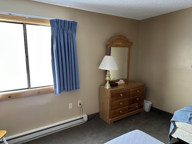 bedroom featuring a baseboard heating unit, dark colored carpet, a textured ceiling, and baseboards