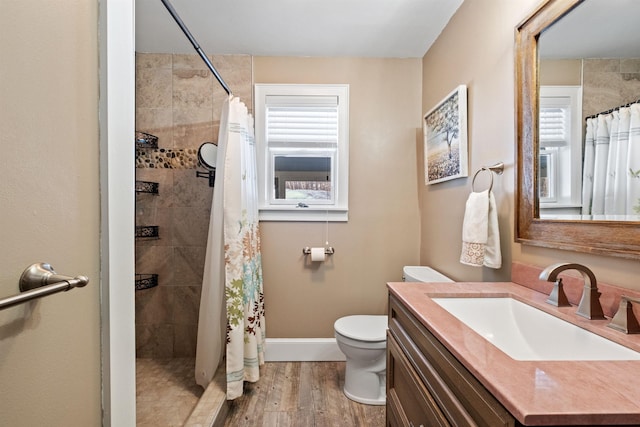 full bathroom with plenty of natural light, a tile shower, and wood finished floors