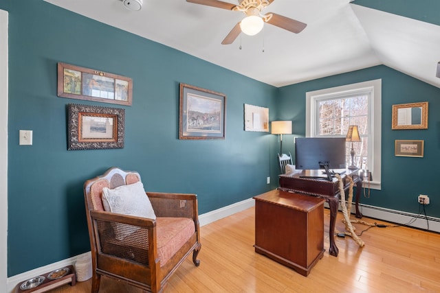 office space featuring baseboards, a ceiling fan, lofted ceiling, baseboard heating, and light wood-type flooring