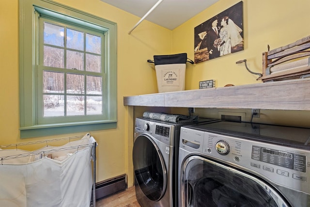 laundry room with laundry area, a baseboard radiator, wood finished floors, and independent washer and dryer