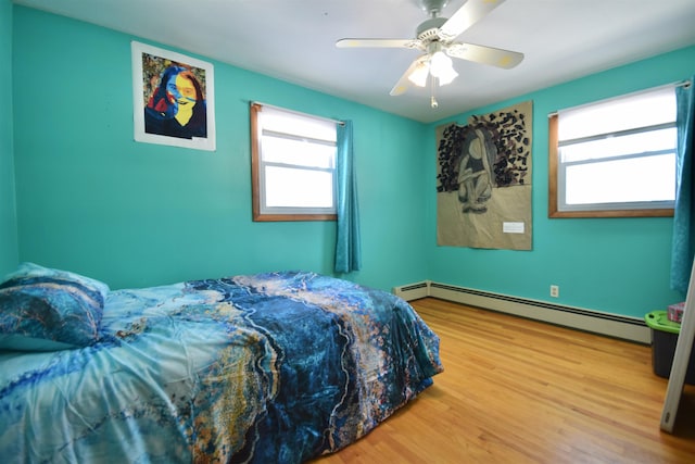 bedroom featuring a baseboard radiator, a ceiling fan, and wood finished floors