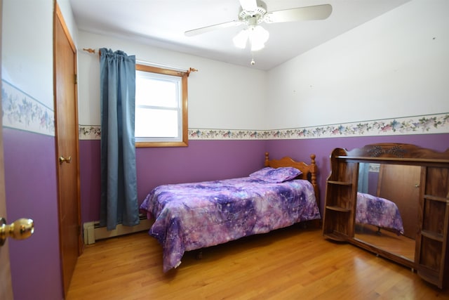 bedroom featuring a baseboard radiator, ceiling fan, and light wood-style flooring