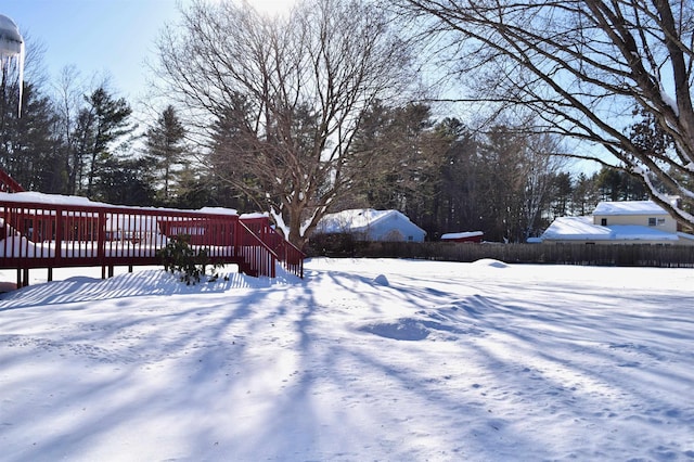 yard layered in snow with a wooden deck