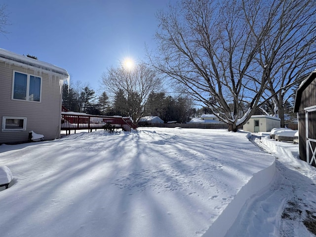 yard covered in snow featuring a wooden deck