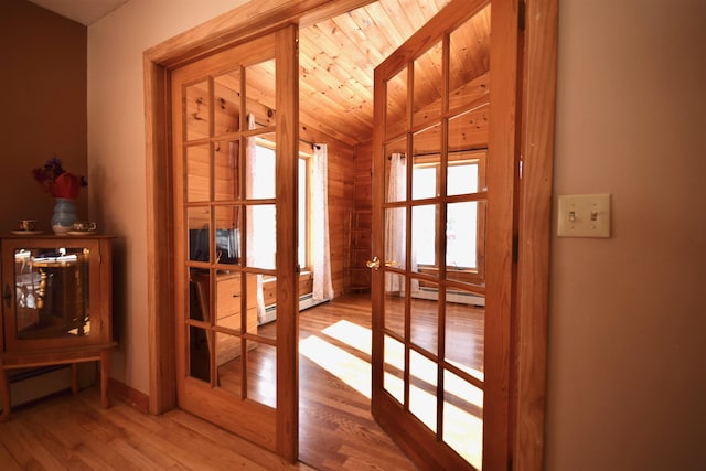 entryway with a baseboard radiator, wood ceiling, wood finished floors, vaulted ceiling, and french doors