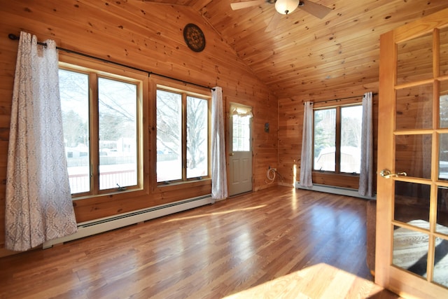 interior space with wooden walls, wood ceiling, a baseboard radiator, wood finished floors, and vaulted ceiling