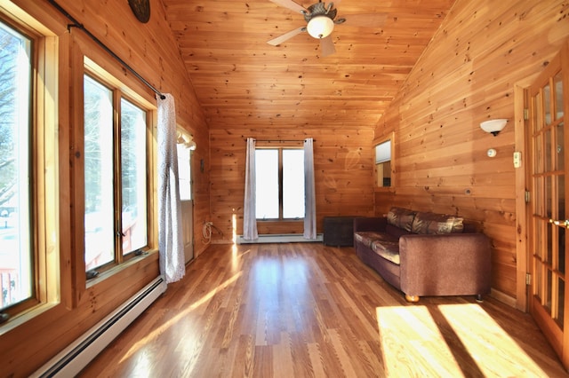 unfurnished living room with lofted ceiling, wooden ceiling, wooden walls, baseboard heating, and light wood finished floors