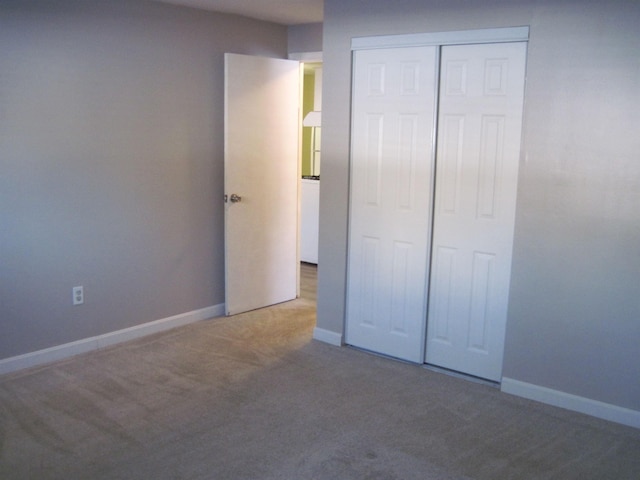 unfurnished bedroom featuring carpet floors, a closet, and baseboards