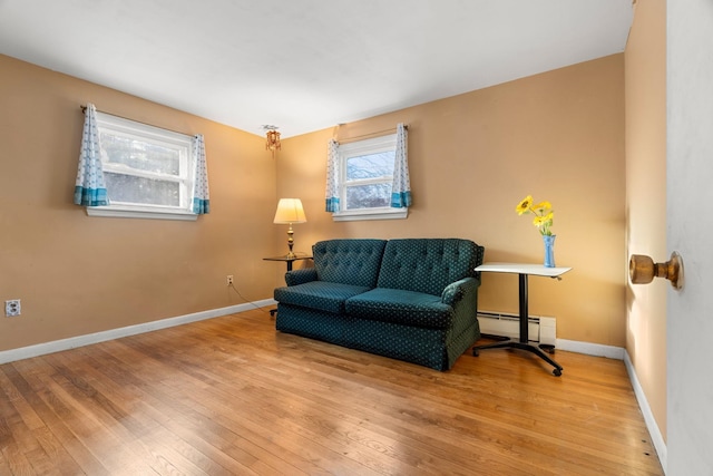 sitting room featuring light wood finished floors, baseboards, and baseboard heating