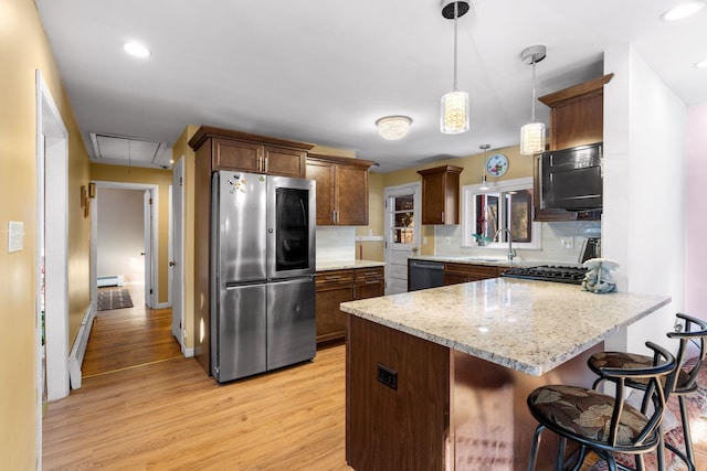 kitchen featuring decorative light fixtures, a peninsula, light stone countertops, smart refrigerator, and a kitchen bar