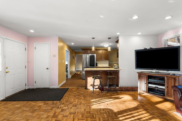 kitchen with recessed lighting, a peninsula, a kitchen breakfast bar, hanging light fixtures, and smart refrigerator