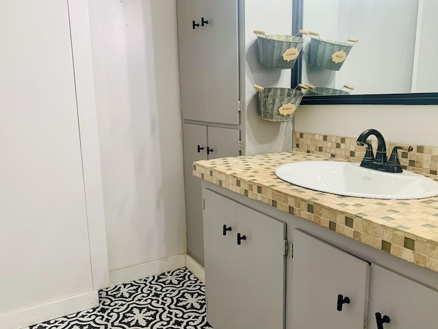 bathroom featuring tasteful backsplash, vanity, and baseboards