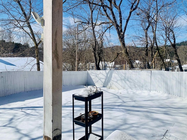 yard covered in snow featuring a fenced backyard