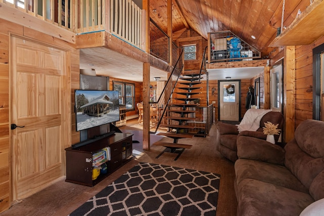 living room with stairs, high vaulted ceiling, wood walls, and wooden ceiling