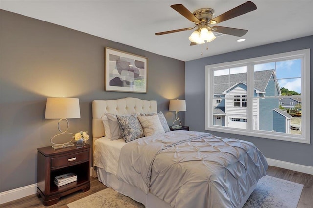 bedroom with ceiling fan, baseboards, and wood finished floors